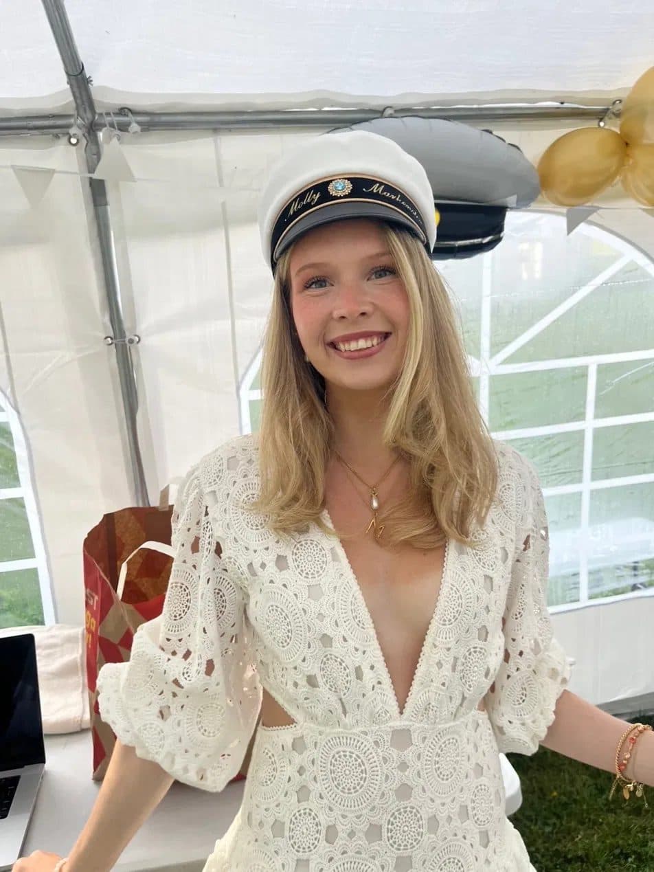 Molly smiling in a white lace dress