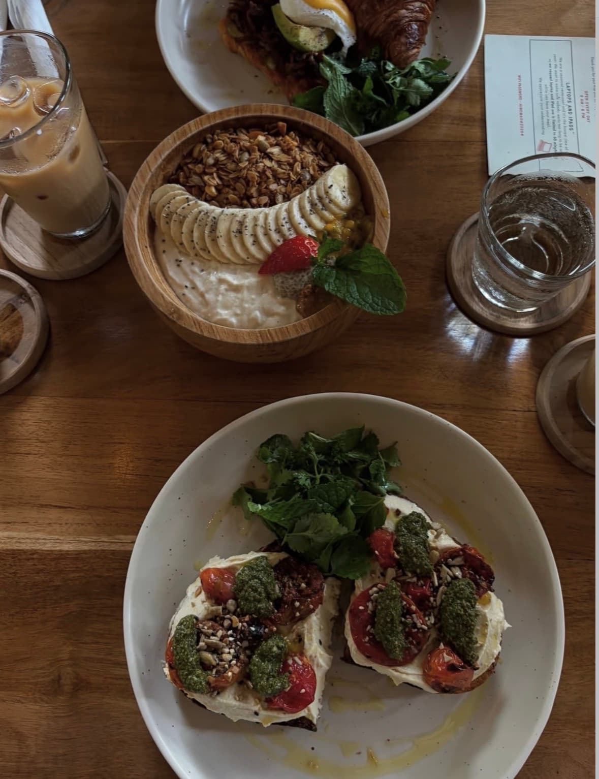 Tomato and pesto toast with a granola bowl and iced coffee
